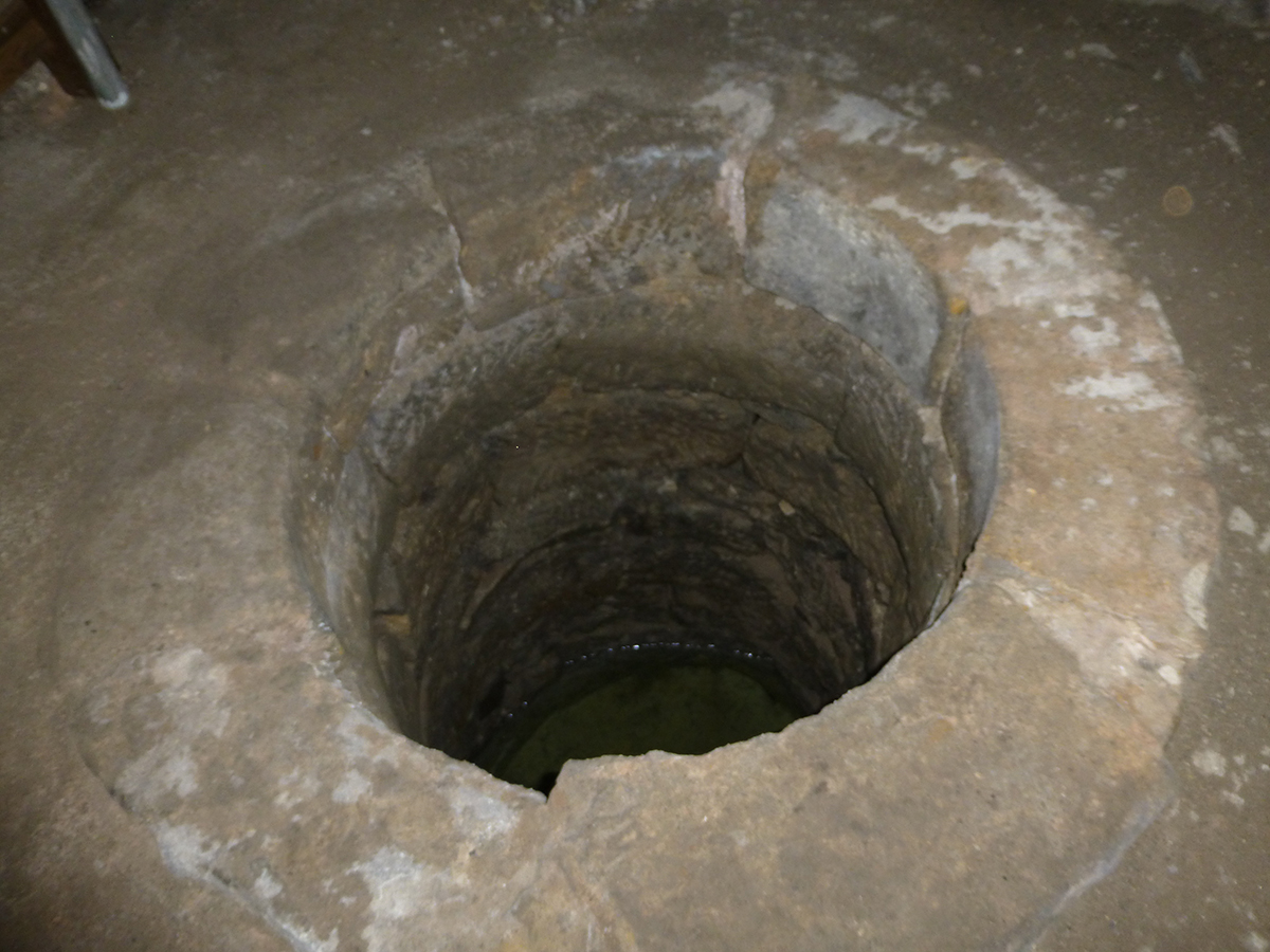 Deep stone water well inside Clackmannan Tower floor