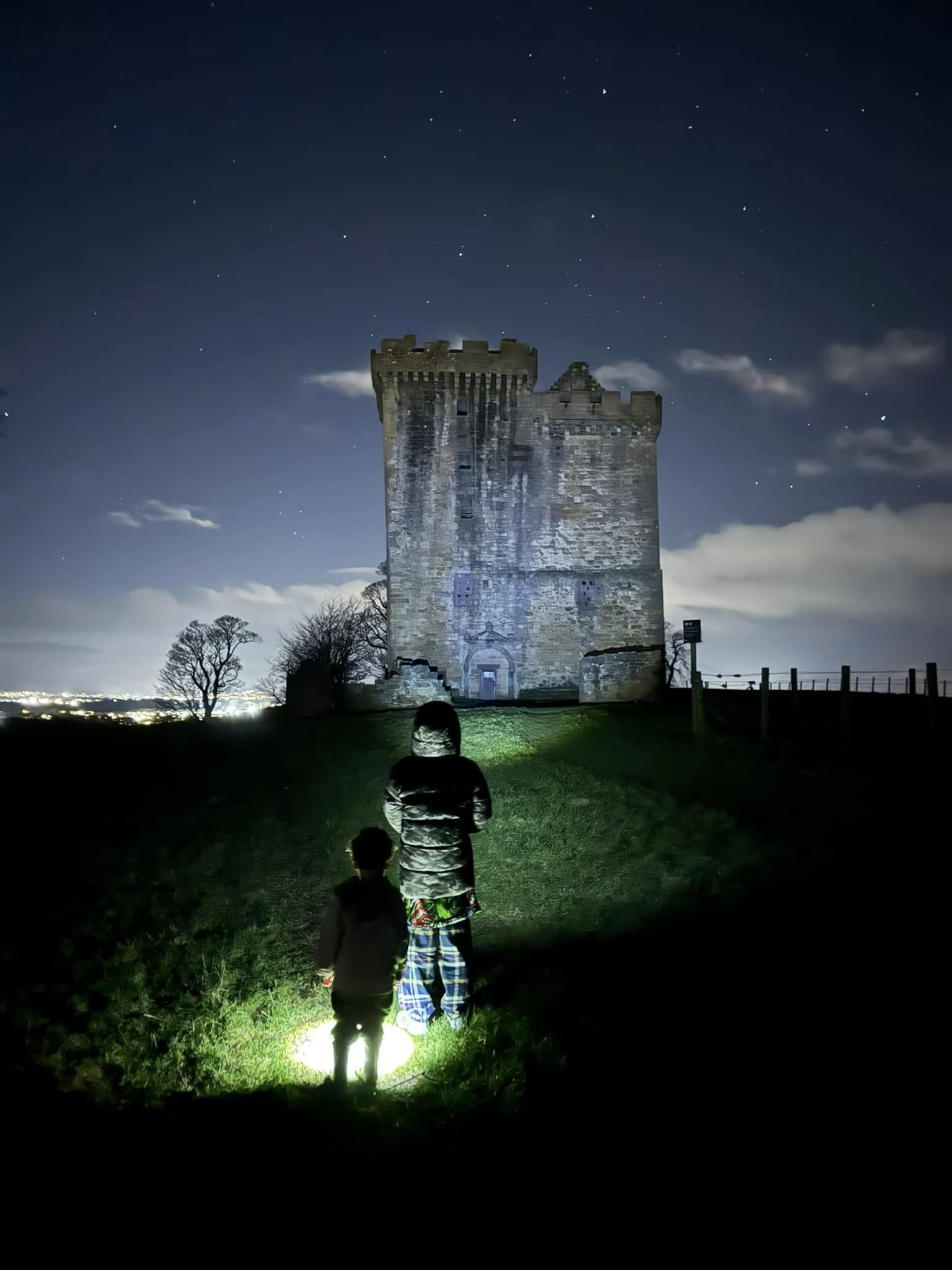 Clackmannan Tower illuminated at night beneath a starry sky